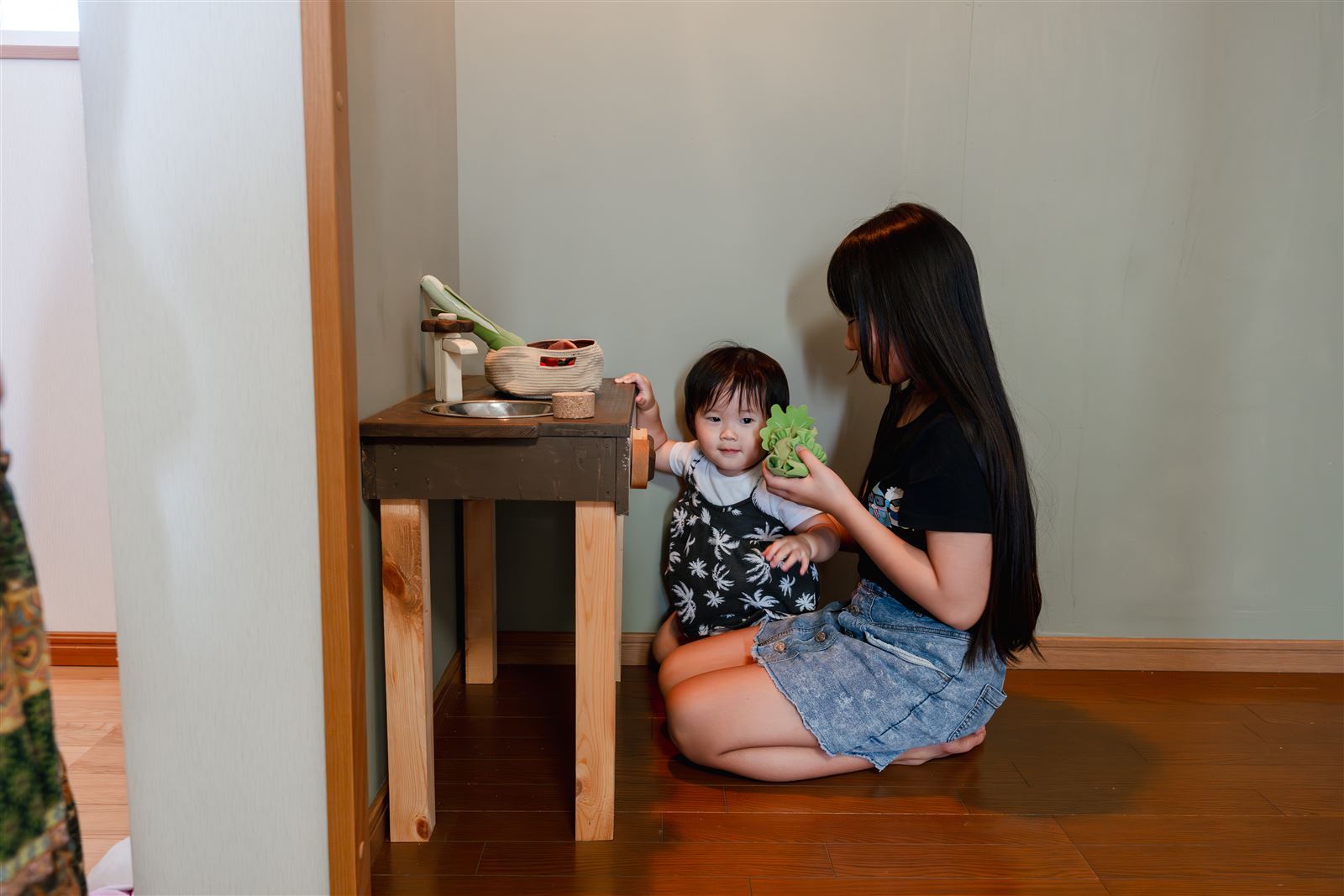 キッズルームの小さなキッチンで遊ぶ親子
